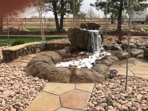 Flowing waterfall feature for backyard | Above & Beyond Lawn & Landscaping